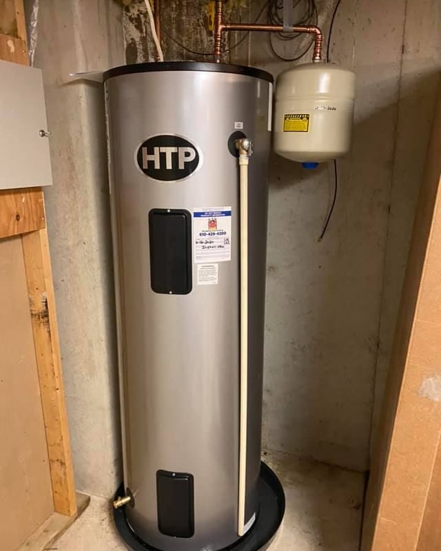 Stainless electric water heater with an expansion tank in a concrete basement